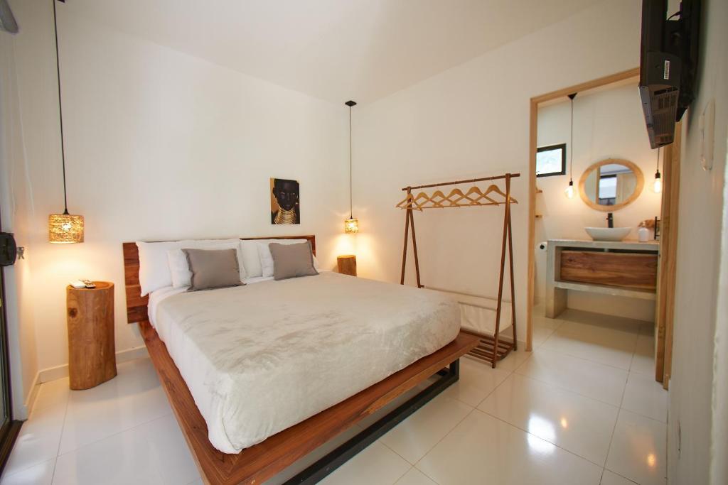 1 dormitorio con cama, espejo y lavamanos en Apartamento de 2 Habitaciones con Piscina, en Santa Teresa Beach