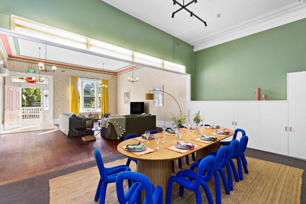 a dining room with a table and blue chairs at Residence - White House Fitzroy in Melbourne