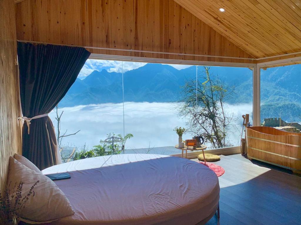 a bedroom with a bed and a large window at Daisy SaPa - Venuestay in Sa Pa