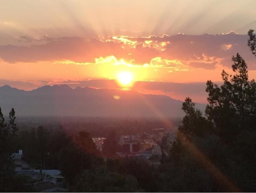 a sunset over a city with the sun in the sky at Mason House in Los Angeles