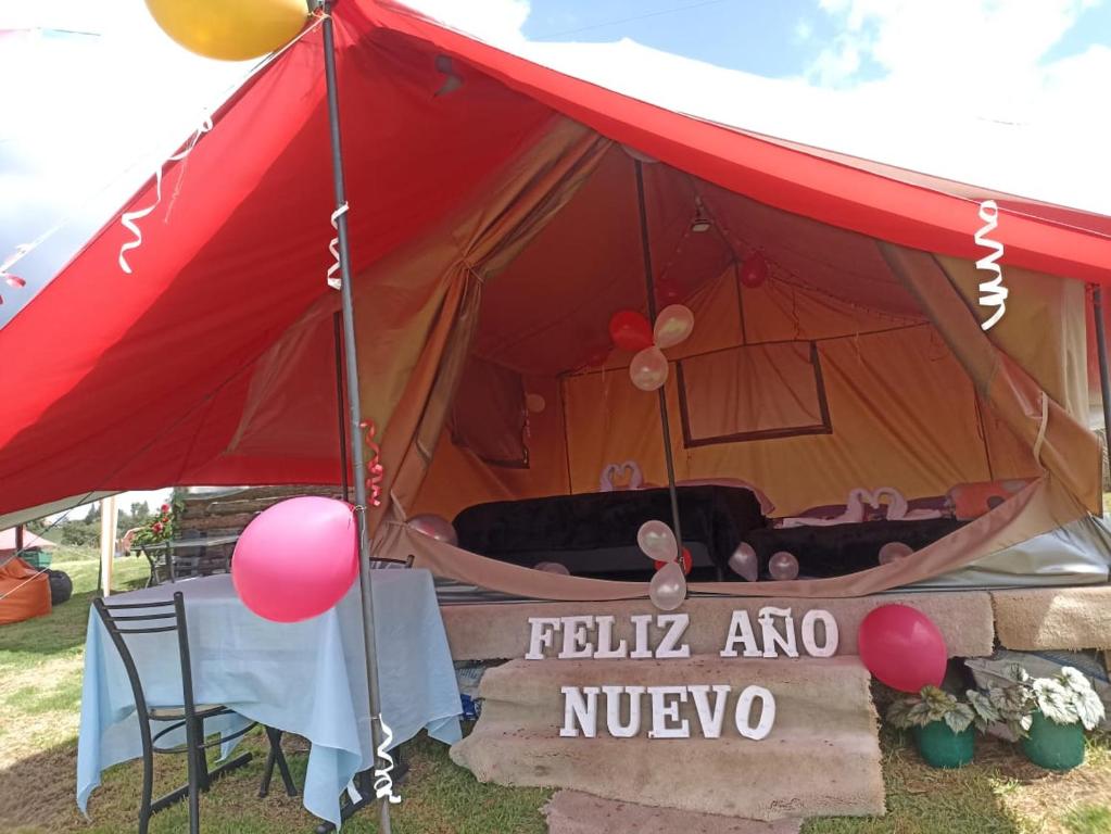 a red tent with a sign that says hello ahno at Yinkana Camping y Glamping in Guatavita