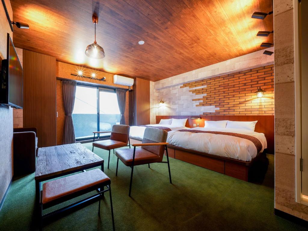 une chambre avec un lit, une table et des chaises dans l'établissement RESI STAY BRiX, à Kyoto