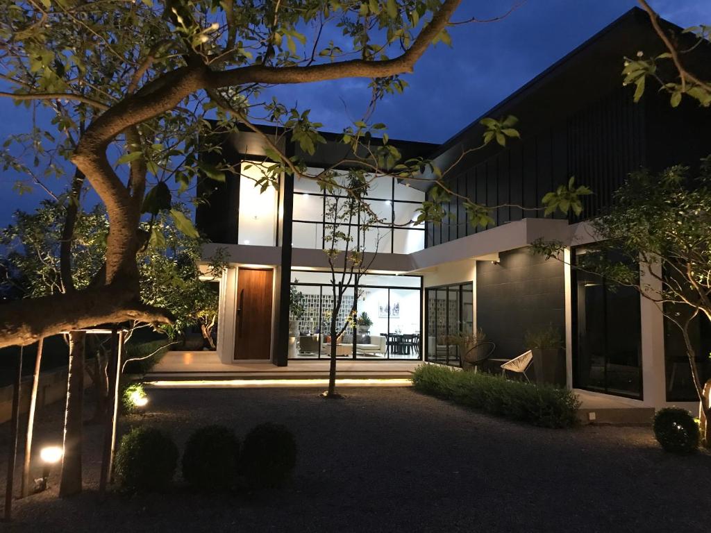 una casa con una fachada de cristal por la noche en THE OAK’S en Chiang Rai