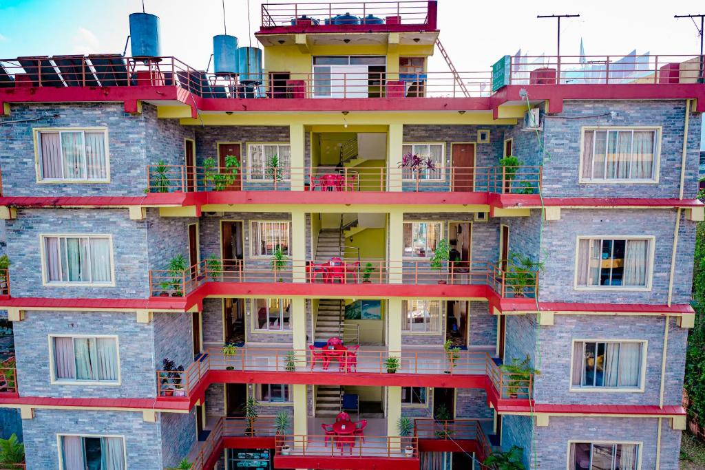 an apartment building with red balconies and tables at Hotel Peace Stupa in Pokhara