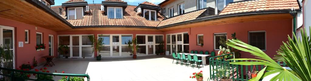 a large house with a courtyard in front of it at Hostel Terasa in Novi Sad