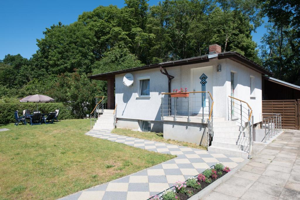 ein kleines Haus mit einer Veranda und einem Hof in der Unterkunft Ferienhaus Pankow in Berlin
