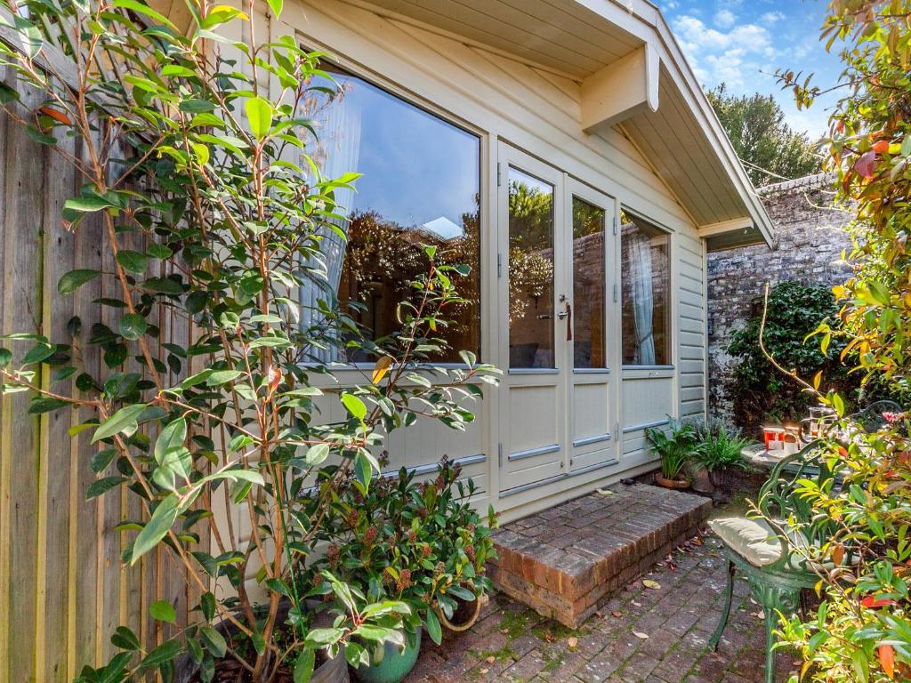 a garden room with a window and some plants at The Lodge in Hurstpierpoint