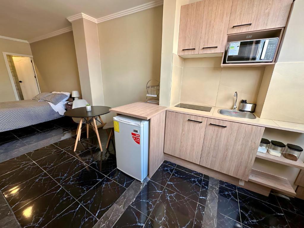 a small kitchen with a sink and a table at Suitesecu Cuenca in Cuenca