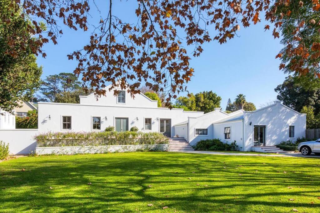 a white house with a green lawn at Maroon Belles in Cape Town