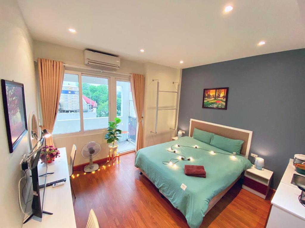 ein Schlafzimmer mit einem grünen Bett und einem Fenster in der Unterkunft May - FABULOUS - Phone 09756-59323 in Hanoi