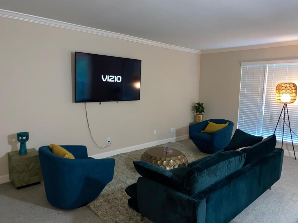 ein Wohnzimmer mit blauen Sofas und einem Flachbild-TV in der Unterkunft Lovely and cozy apartment- Rancho in Rancho Palos Verdes