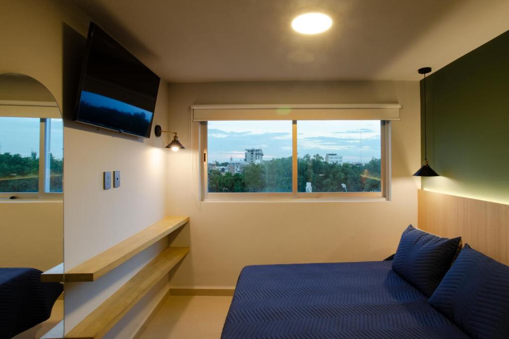 ein Schlafzimmer mit einem Bett und einem großen Fenster in der Unterkunft La Hospedería León in León