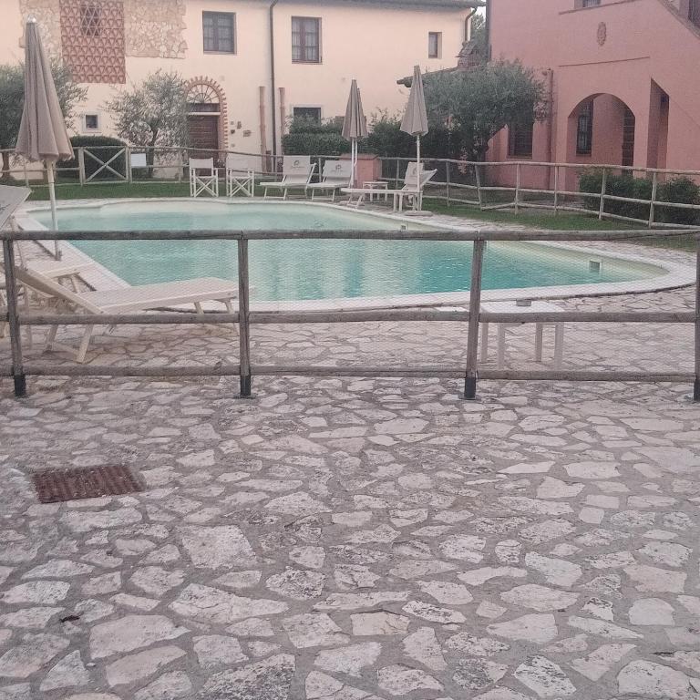 een zwembad met 2 stoelen en een parasol bij Casa Vacanze Giodo in San Vivaldo