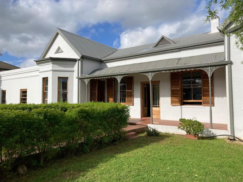 a white house with a black roof at Ramble Guest House in Riversdale