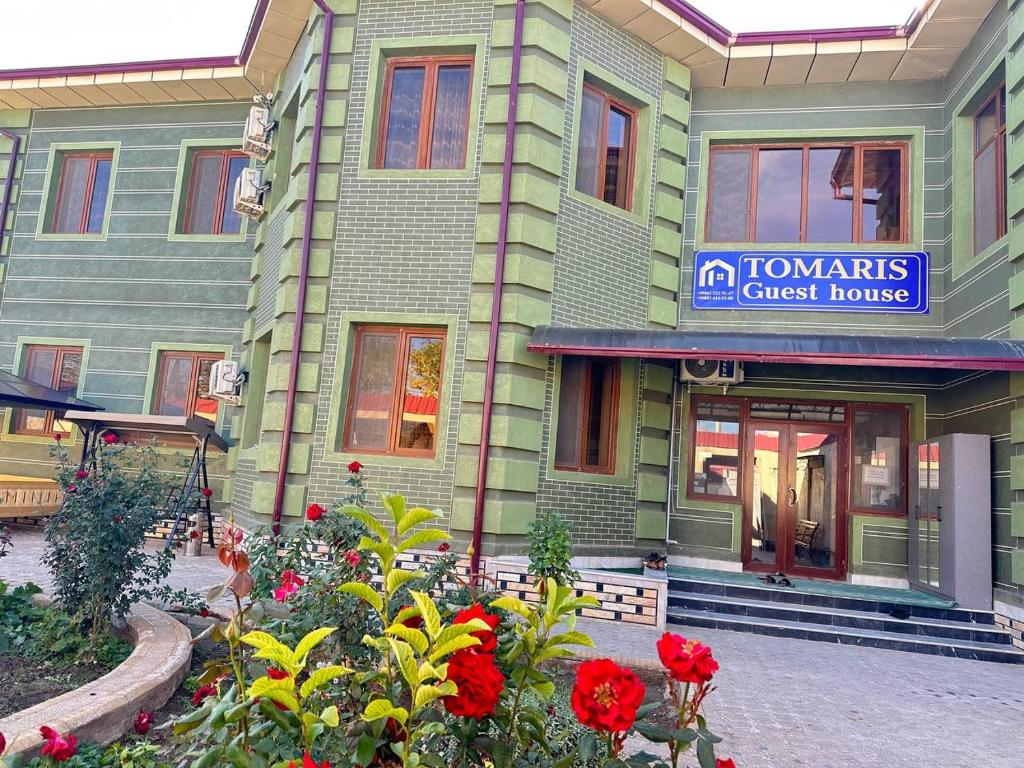 a green building with flowers in front of it at Tomaris in Nukus