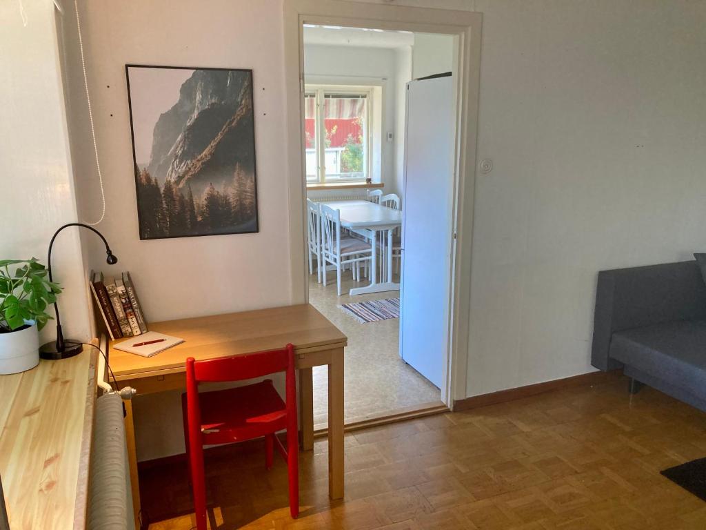 a living room with a desk and a table and a couch at Lägenhet i lugn trädgård in Bygdeå