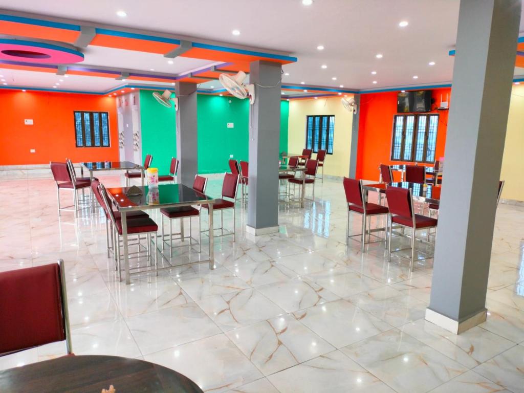 un comedor con mesas y sillas y una pared verde en Hotel Shiv Shakti en Mohaniā