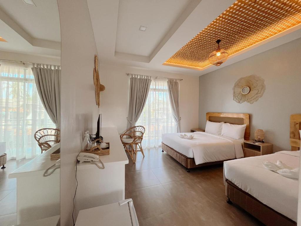 um quarto de hotel com duas camas e uma mesa e cadeiras em Anlio Resort em Dauis