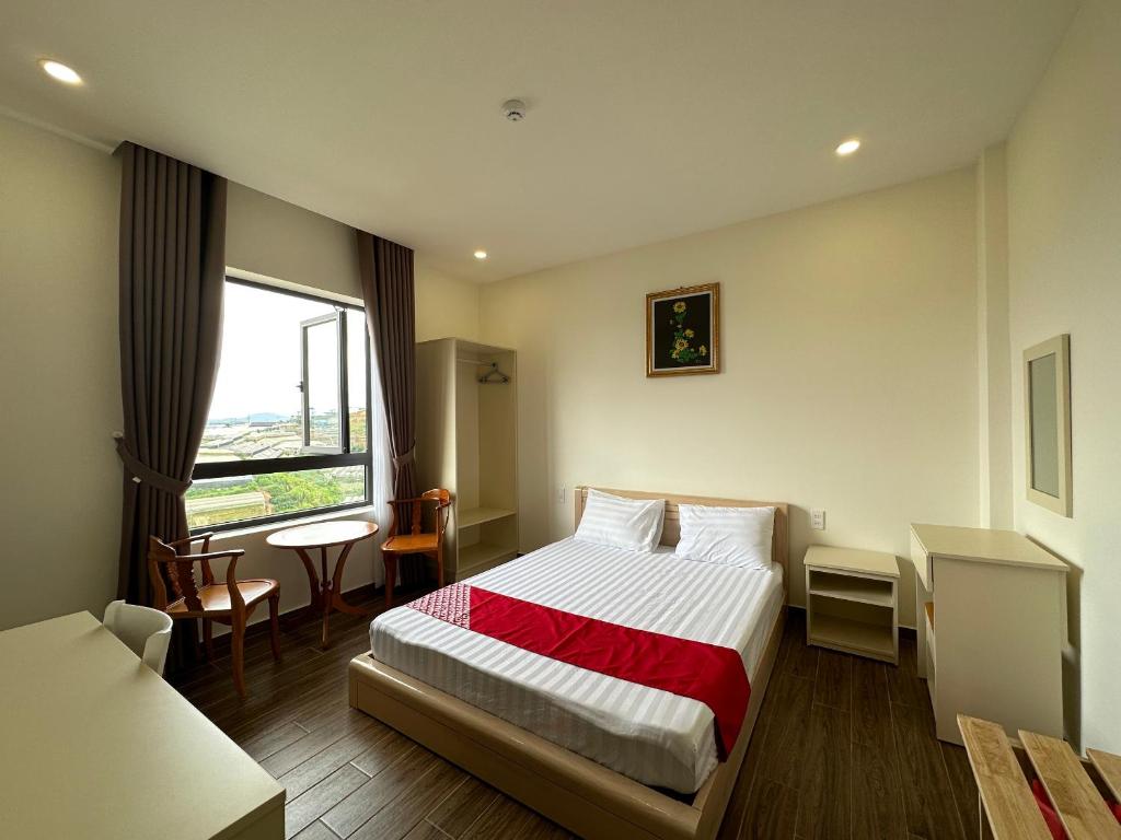 a hotel room with a bed and a window at Capital O 1208 Phong Van Villa in Da Lat
