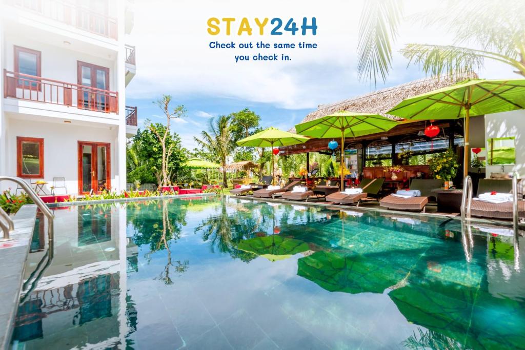 een zwembad in het resort met stoelen en parasols bij Crony Villa - STAY 24H in Hội An