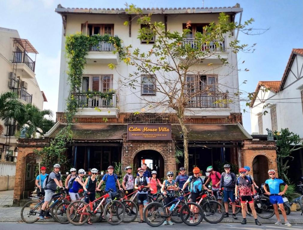 un grupo de personas en bicicleta delante de un edificio en Calm House Hotel Hoi An 1, en Hoi An