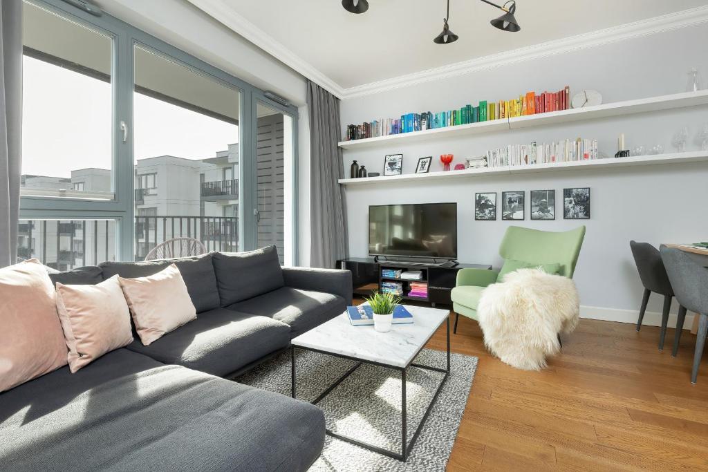 a living room with a couch and a table at Cozy Apartment Gieysztora Wilanów by Renters in Warsaw