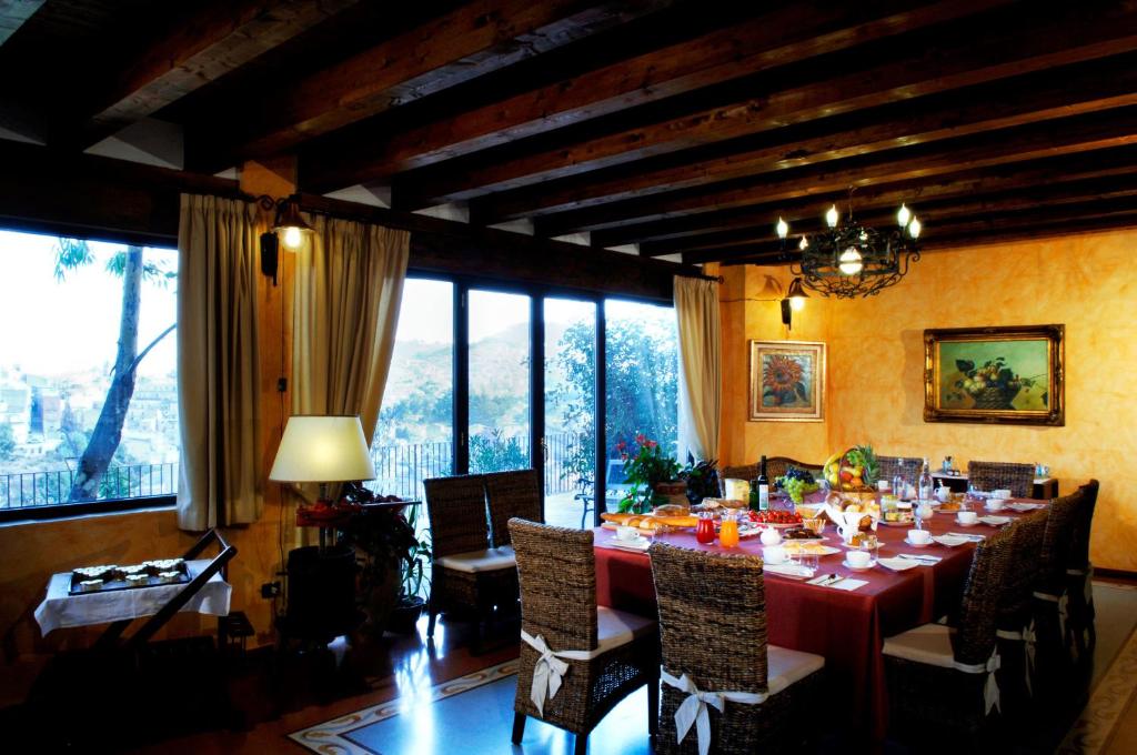 a dining room with a red table and chairs at La Casa sulla Collina d'Oro in Piazza Armerina