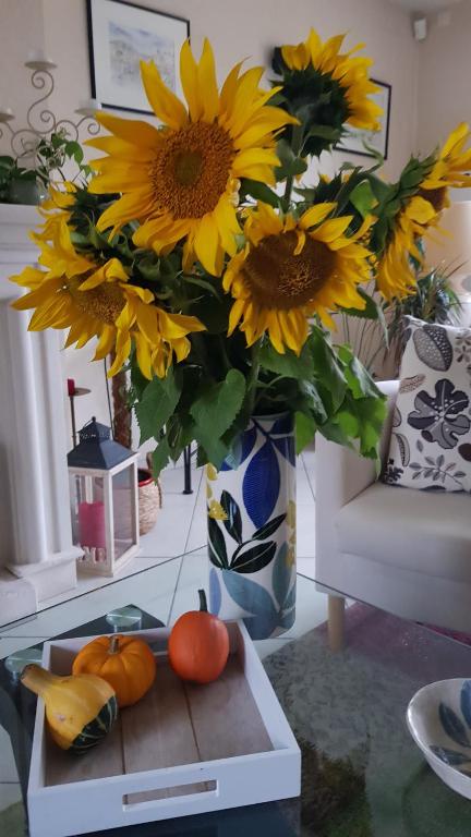 a vase filled with sunflowers and pumpkins on a table at Chez Laurence &amp; RV in Vauréal