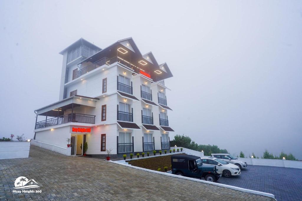 a white building with a car parked in a parking lot at Hazy Heights 360 in Munnar