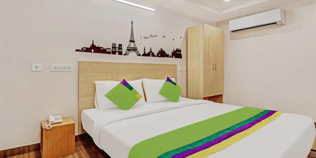 ein Schlafzimmer mit einem großen weißen Bett mit einer bunten Decke in der Unterkunft De Crown Luxury Hotel in Kakinada