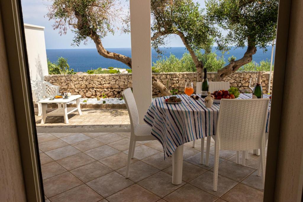 un tavolo e sedie su un patio con vista sull'oceano di Dimora Dei Turchesi a Gagliano del Capo