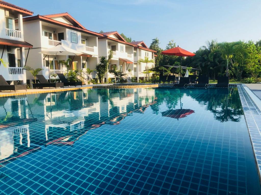 a swimming pool in front of some buildings at Maikhao Beach Residence in Mai Khao Beach