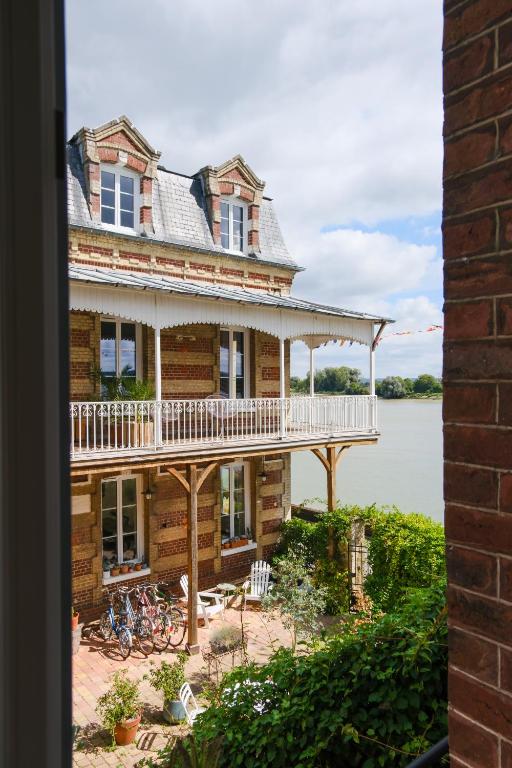 une grande maison avec des vélos garés à l'extérieur dans l'établissement La Maison Plûme, à Villequier