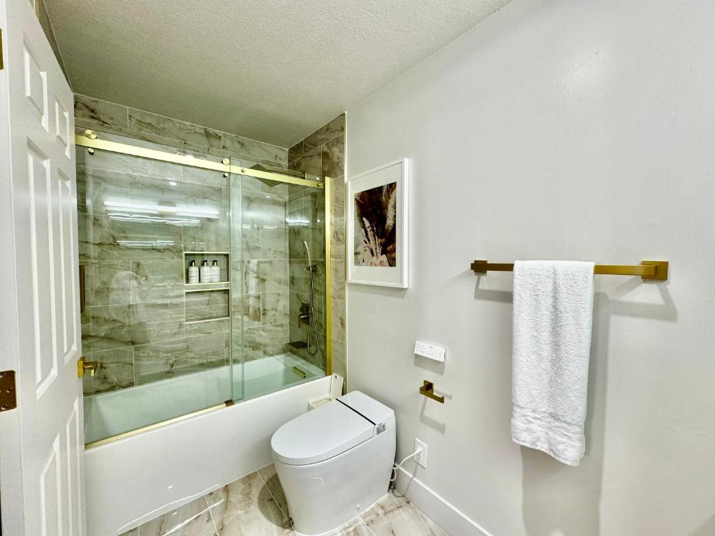 uma casa de banho com um WC e uma cabina de duche em vidro. em Stunning apartment steps from Ocean Beach em São Francisco