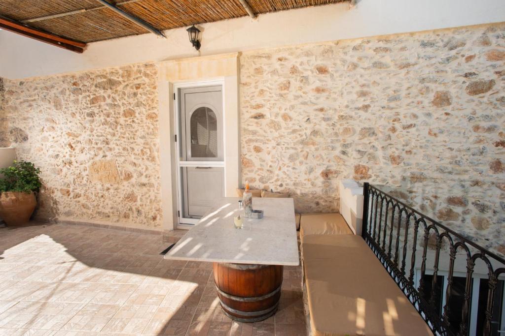 Zimmer mit einem Tisch und einer Ziegelwand in der Unterkunft Eirini's Traditional House in Lístaros