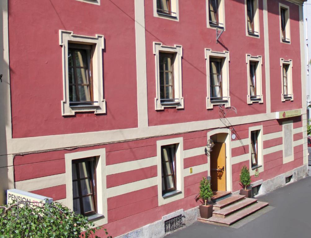 ein rotweißes Gebäude mit Treppen und Fenstern in der Unterkunft Pension Stoi budget guesthouse in Innsbruck