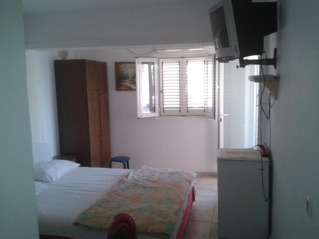 a small bedroom with a bed and a window at Guest House Vila Jasna in Budva