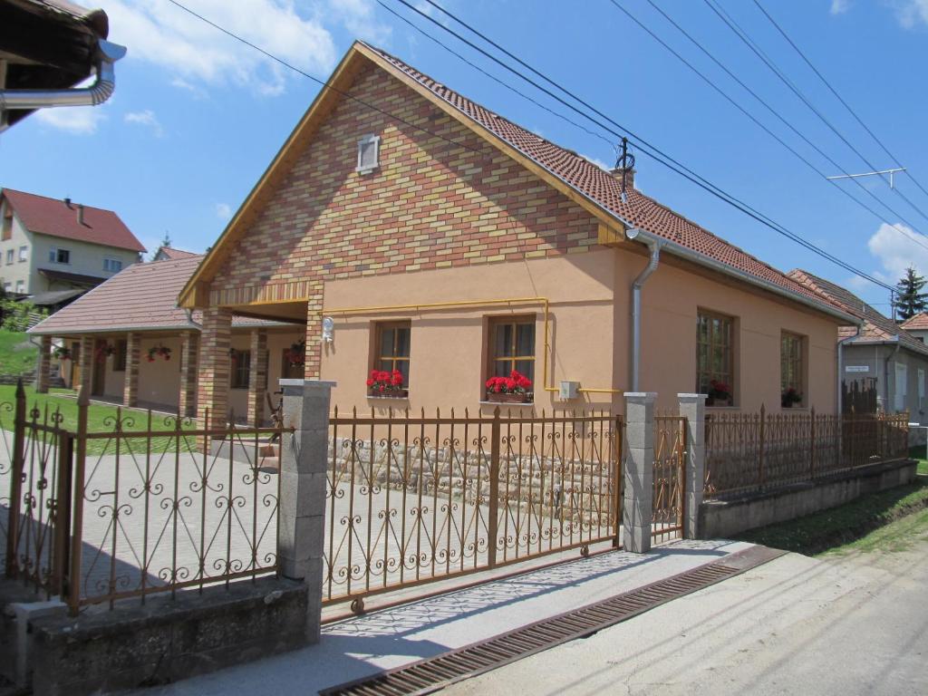 ein Haus mit einem Tor davor in der Unterkunft Tavi Fészek Vendégház in Bánk