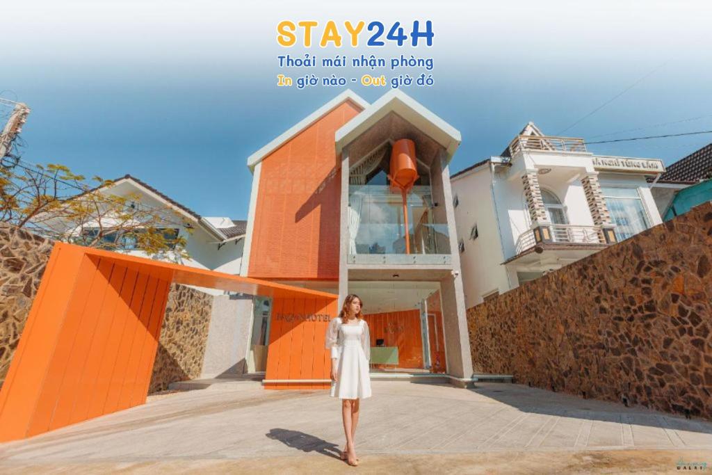 a woman in a white dress standing in front of a house at RAON Bazan Hotel - STAY 24H in Da Lat