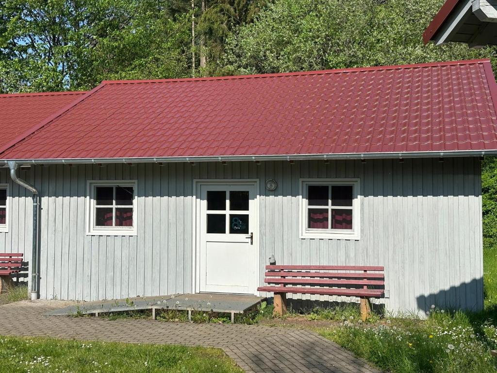 um pequeno edifício branco com um telhado vermelho e um banco em Achtsamkeit - b43232 em Losheim