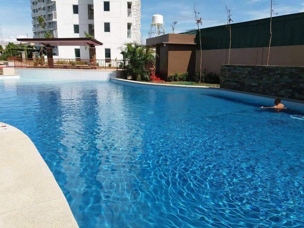 a large blue swimming pool with a person laying in it at anuva residences in Manila