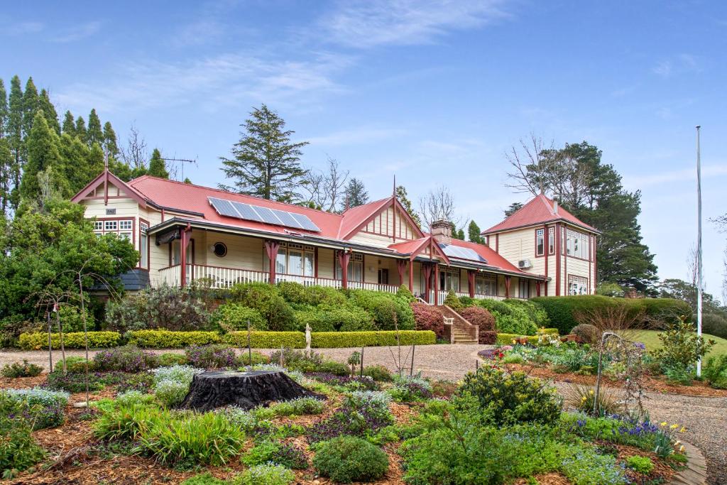 uma casa com um jardim em frente em Bethany Manor B&B call them for Guaranteed Cheapest Price em Leura