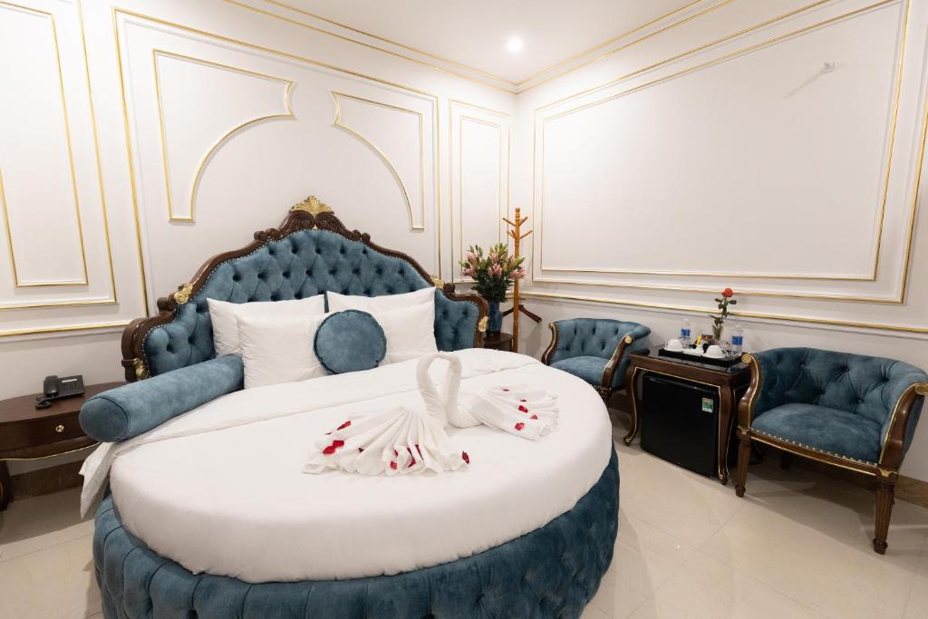 sypialnia z niebiesko-białym łóżkiem i krzesłami w obiekcie Royal Hotel Sài Đồng - Long Biên w mieście Hanoi