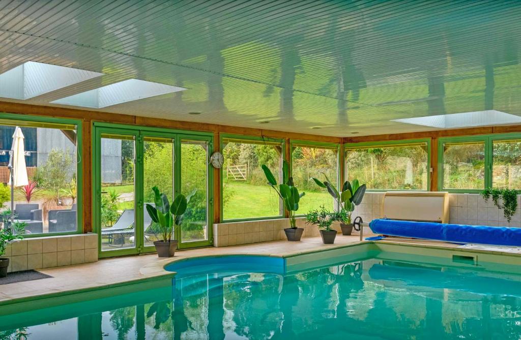 una piscina en una casa con ventanas en Les Pierres Bleues en Saint-Coulitz