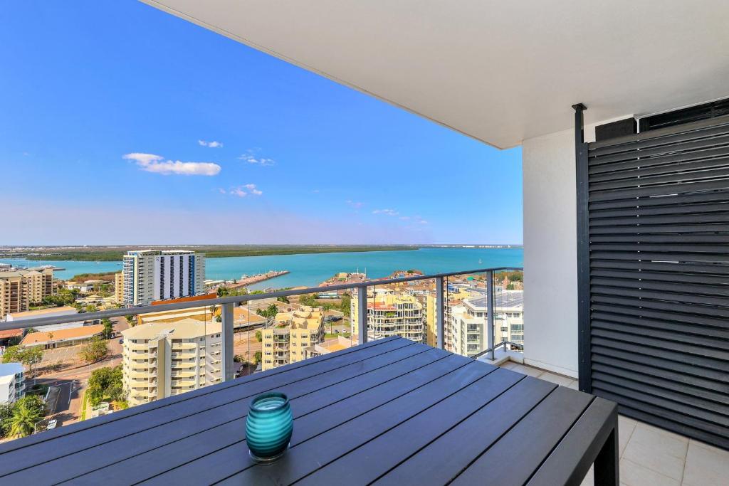 a balcony with a table and a view of the ocean at Darwin City - The Oaks with Harbour Views in Darwin