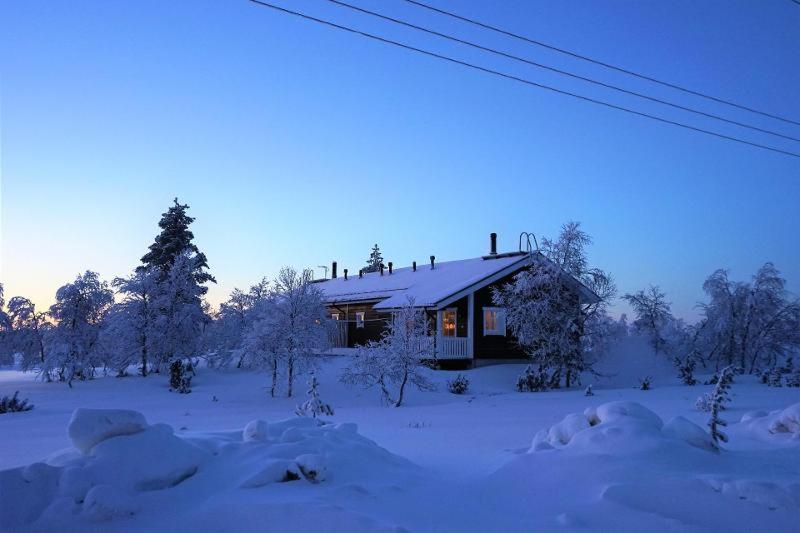 a house in a snow covered field with a house at Twin Peaks Urupää A Saariselkä in Saariselka