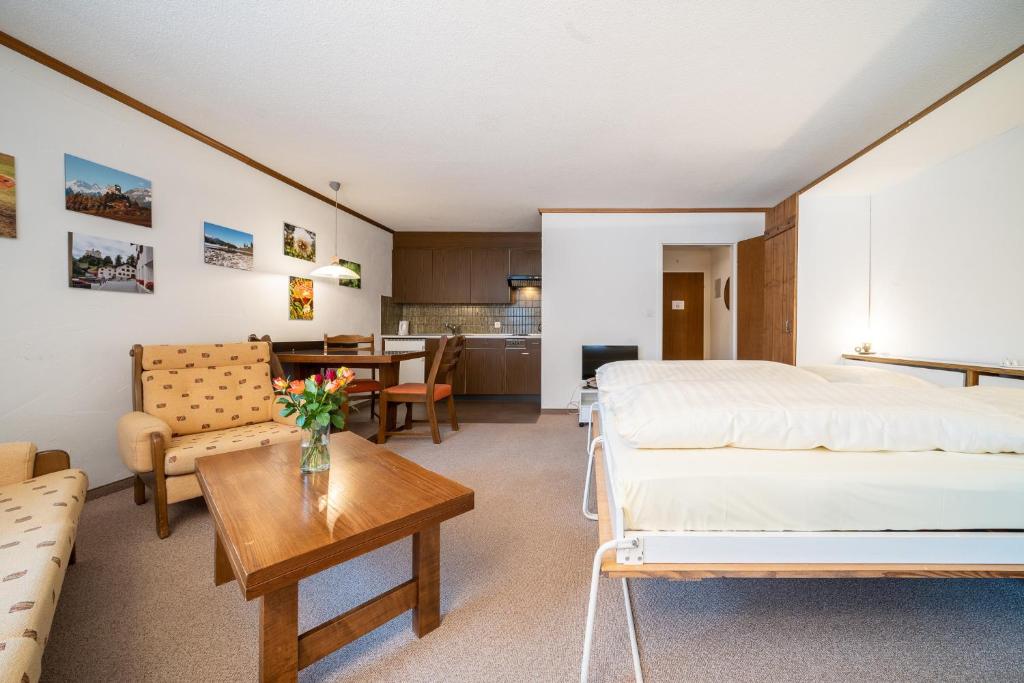 Habitación de hotel con 2 camas y mesa en 6304 Preislich attraktives Studio mit Suedbalkon am Wanderweg en Vulpera