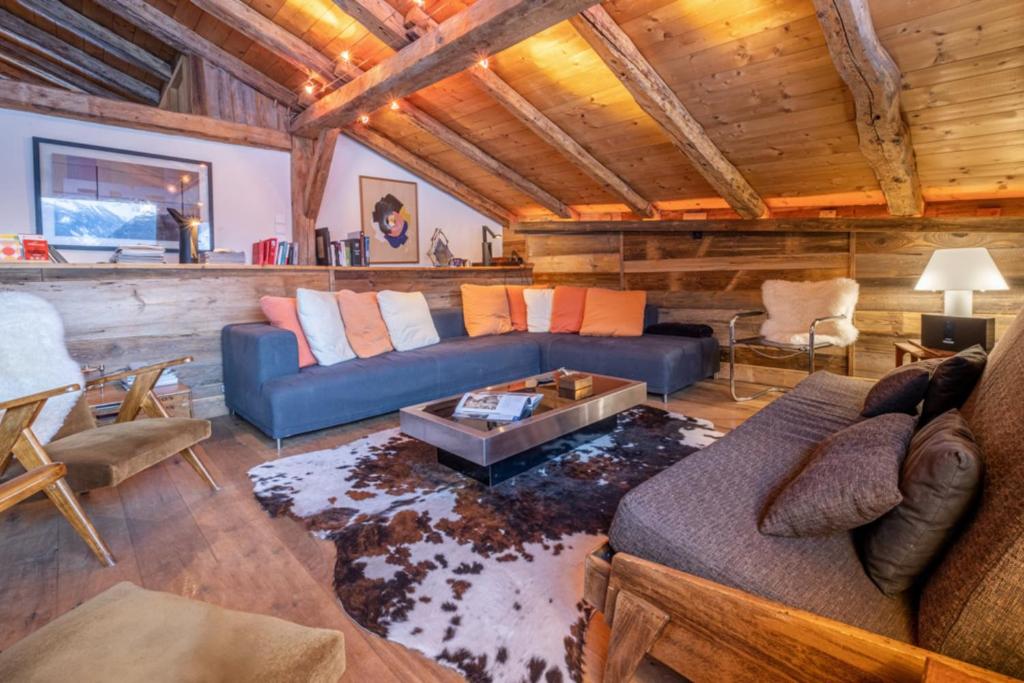 ein Wohnzimmer mit einem blauen Sofa und einem Tisch in der Unterkunft Authenthic Chalet Ski on Les Houches Chamonix in Les Houches