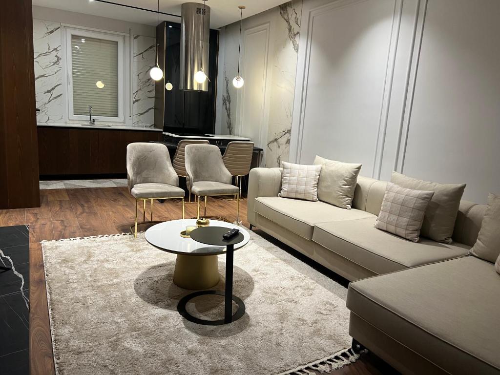 sala de estar con sofá, mesa y sillas en Regal retreat Apartment, en Shkodër