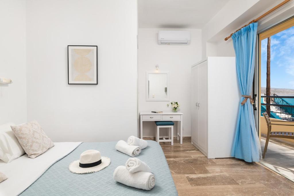 a white room with a bed with towels on it at Evdokia Αpartments & Dimitra Village in Agia Marina Nea Kydonias